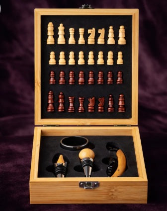 An open wooden game set box displaying a 30-piece wooden chess set and three wine decanters on a dark purple velvet background.