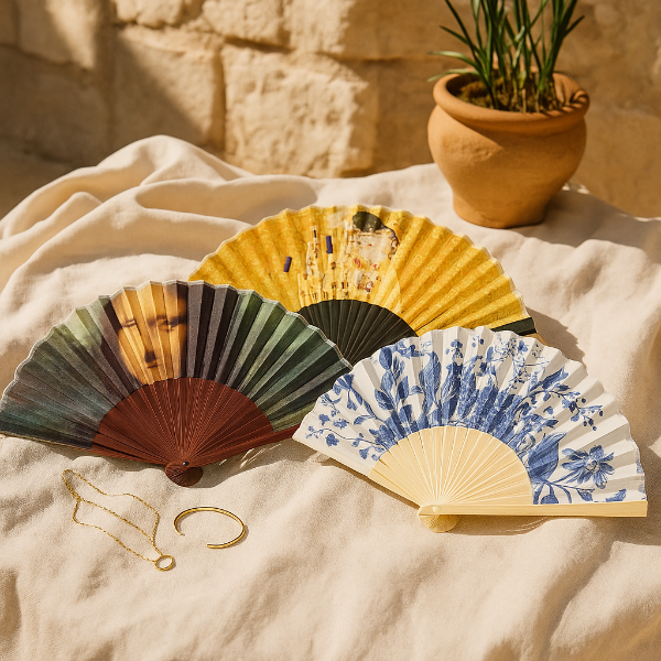 Colorful hand fans on a textured surface with a plant and jewelry in the backgroundlepeza, ručna lepeza, art lepeza, lepeza inspirirana umjetnošću, lepeza s umjetničkim motivom, muzejska lepeza, lepeza za ljeto, ljetna lepeza, elegantna lepeza, dekorativna lepeza, bambus lepeza, lepeza od bambusa, lepeza od tkanine, modna lepeza, poklon za ljubitelje umjetnosti, poklon za nju, originalan poklon, umjetnički poklon, muzejski suvenir, Rijksmuseum lepeza, nizozemska umjetnost, poznate slike, art dodatak, ljetni