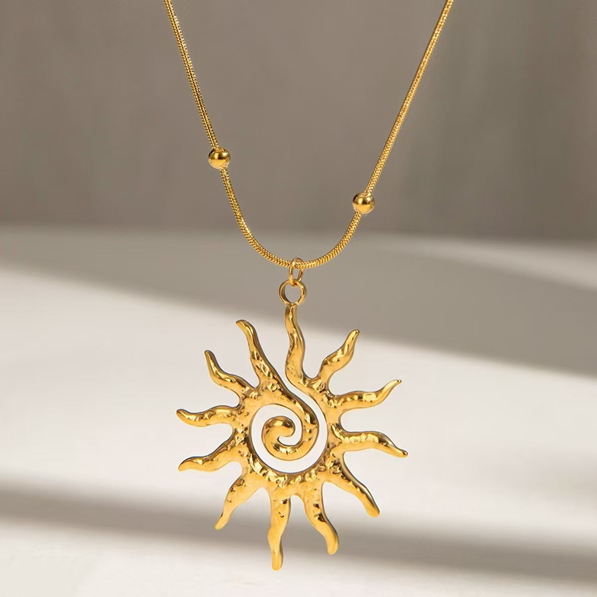ogrlica s motivom sunca, hammered sun necklace, ZAYA x COSMOS, solarna ogrlica, vodootporni nakit, minimalistička zlatna ogrlica, francuski brend nakita, zaya-hr.com, chic ljetni nakit, poklon za nju, nakit s prirodnim simbolima, ogrlica za svaki dan, spiritual sun jewelry, elegantan sunčani privjesak, modni dodatak 2025, layering necklace inspiration