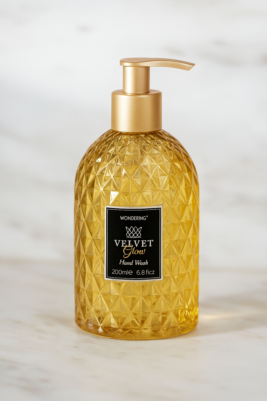 Gold bottle of Wonderin Velvet Glow Hand Wash on a light background